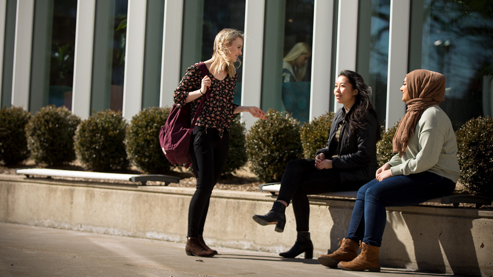 Three students talking outside.